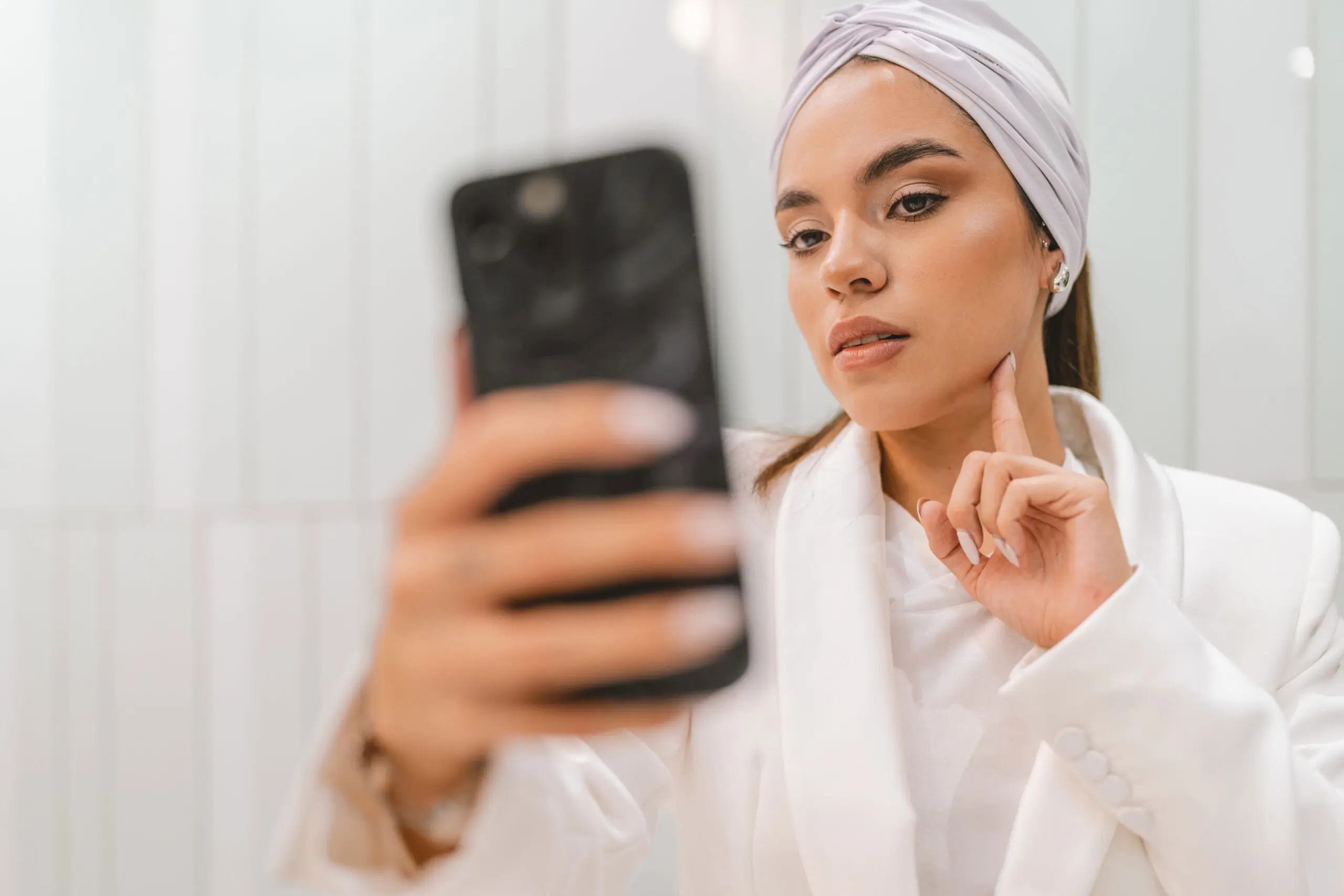 Woman taking a close-up selfie to submit a skin photo for an online dermatologist consultation.